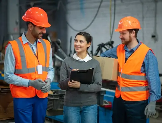 Mulher com uniforme de segurança do trabalho segurando uma prancheta conversando com dois colegas homens com uniforme de segurança do trabalho. pessoas com equipamentos de segurança em seus locais de trabalho, mulher, indústria de engenharia de construção, asiática sorridente, capacete de segurança, visita a área de construção, inspeção, prancheta, segurança do trabalho, e social, e-social, esocial, segurança, saúde ocupacional.